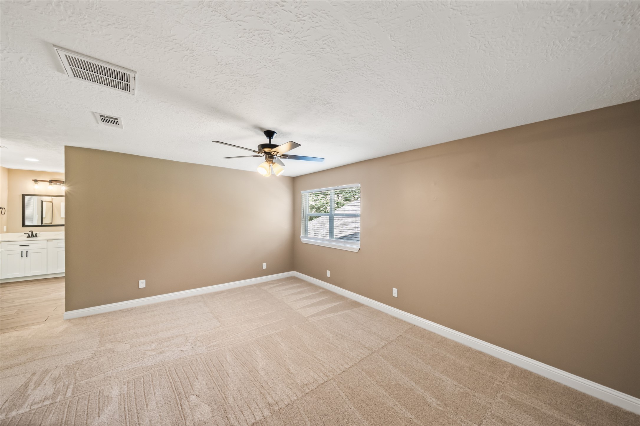 3019 Ramblewood Road Montgomery, TX 77356 - Photo 27 of 40 Spacious primary bedroom with soft neutral tones, plush carpet, and an en-suite bath just steps away.