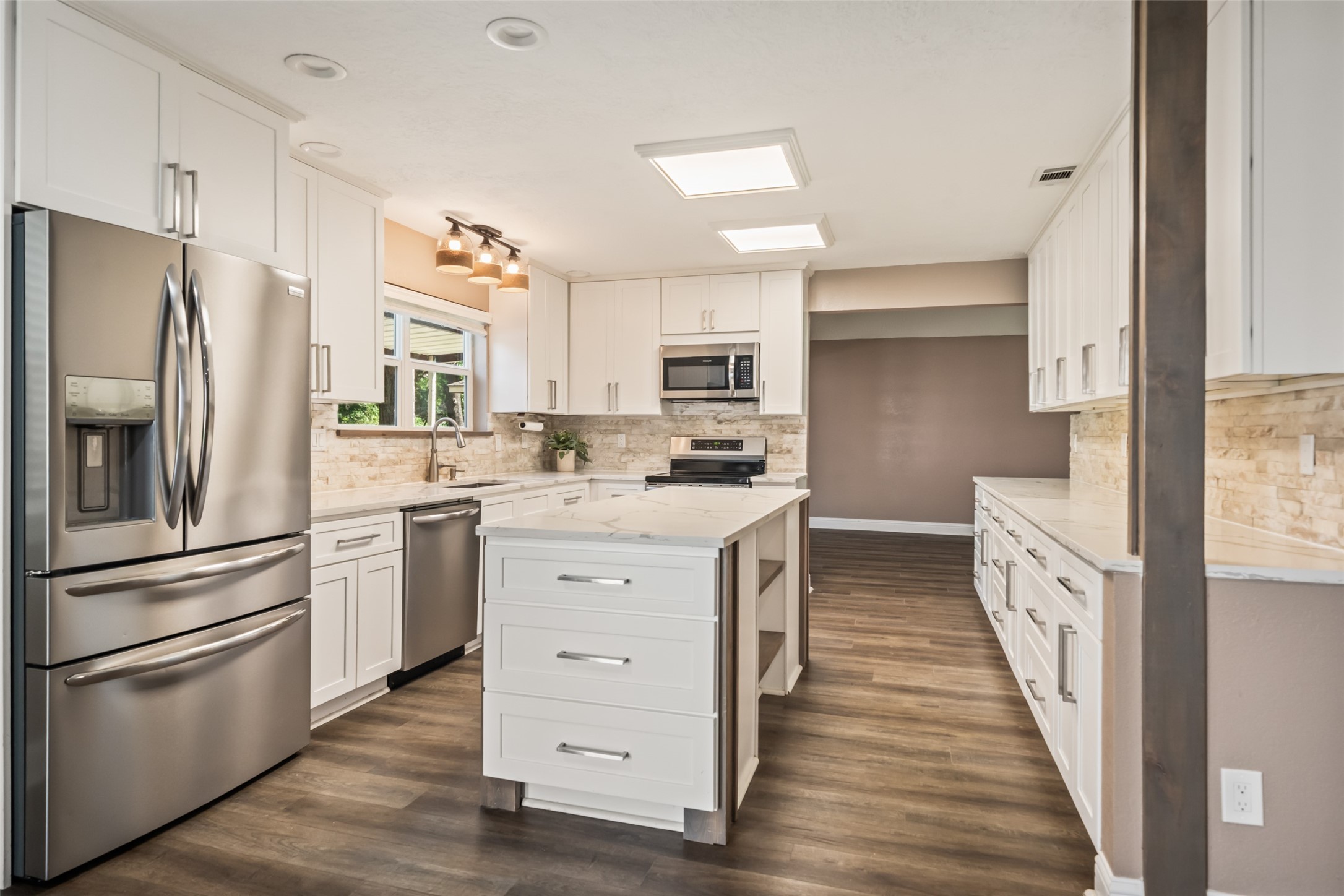 3019 Ramblewood Road Montgomery, TX 77356 - Photo 8 of 40 This stylish kitchen features 2021 Frigidaire stainless steel appliances, including an induction stove, an island with storage, and elegant Calacatta Gold quartz counters.