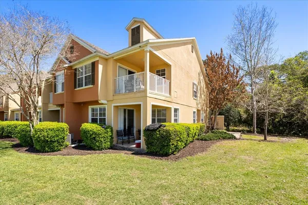 a view of a house with a big yard and large trees