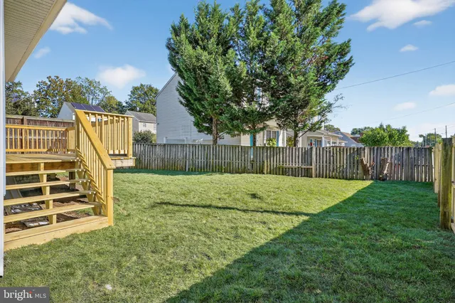 a view of a backyard with wooden fence