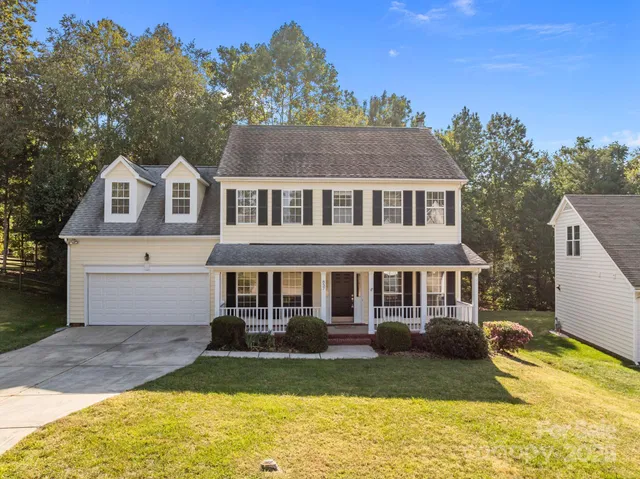 a front view of a house with yard and green space