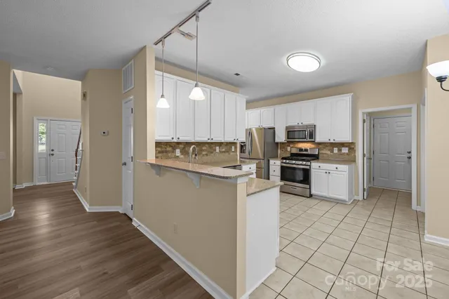 a kitchen with stainless steel appliances granite countertop a refrigerator and a stove top oven