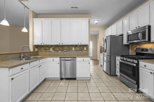 a kitchen with stainless steel appliances granite countertop a refrigerator sink and cabinets