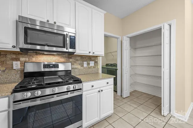 a kitchen with stainless steel appliances white cabinets and stove
