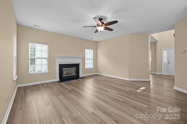 a view of empty room with wooden floor and fireplace