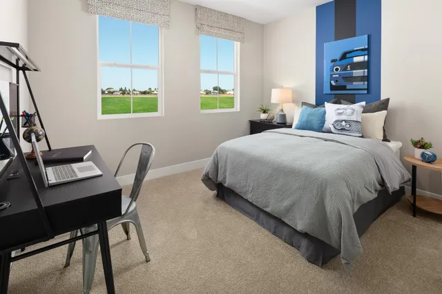 a bedroom with a bed a desk and chair