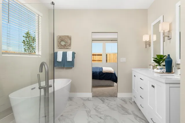 a en suite spacious bathroom with a granite countertop sink a mirror and bathtub