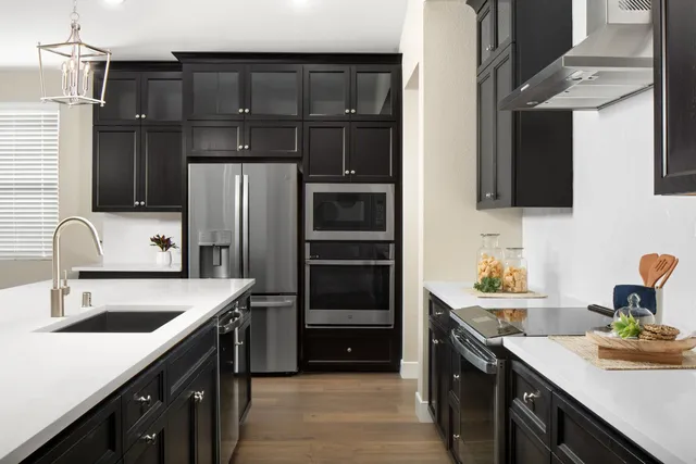 a kitchen that has a sink cabinets counter space and appliances