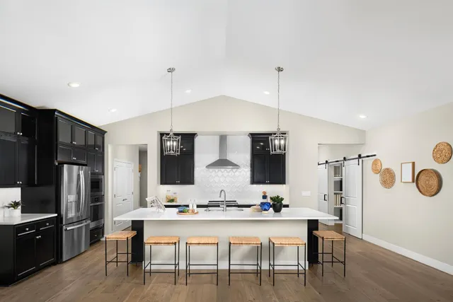 a view of kitchen with kitchen island stainless steel appliances a dining table and chairs