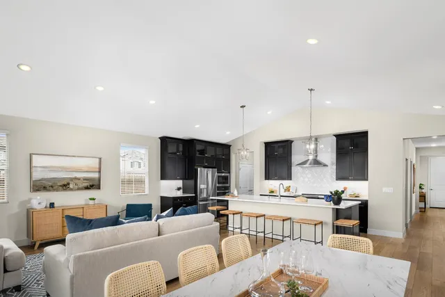 a living room with furniture kitchen view and a flat screen tv