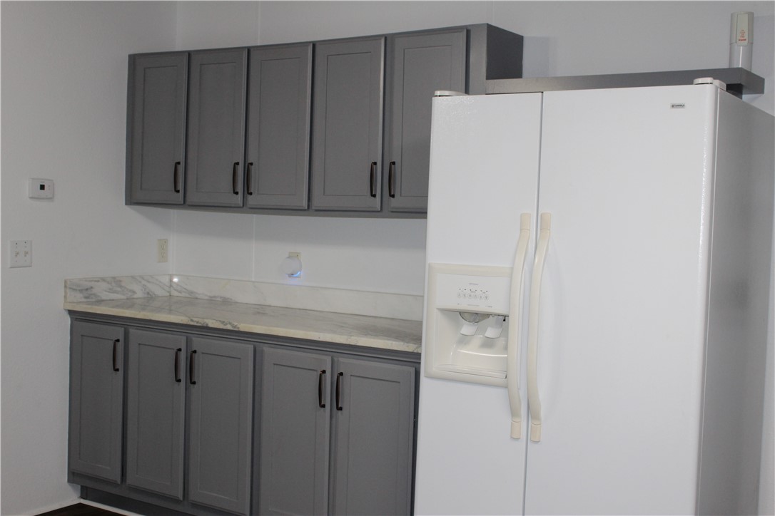 125 Lagarto Ferry Mathis, TX 78368 - Photo 10 of 38 a kitchen with a white cabinets and a refrigerator