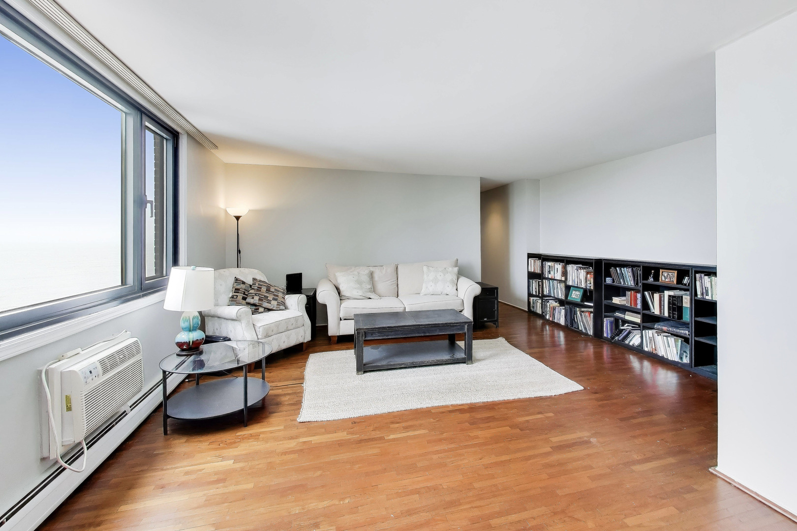 6325 North Sheridan Road, Unit 1602 Chicago, IL 60660 - Photo 5 of 38 a living room with furniture and a book shelf