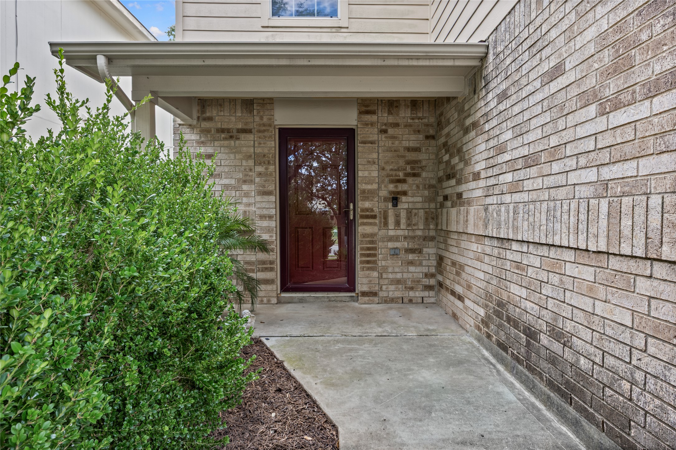 198 Black Forest Road Buda, TX 78610 - Photo 3 of 23 A welcoming brick facade with a prominent red entry door invites you home.