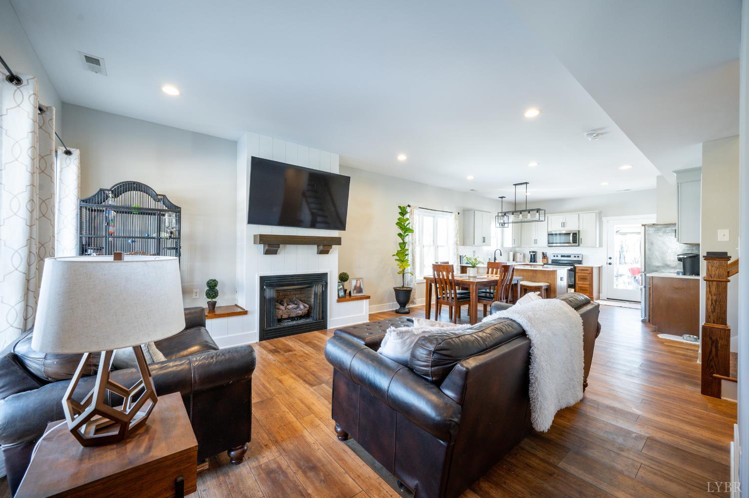 180 Timber Ridge Drive Forest, VA 24551 - Photo 5 of 58 a living room with furniture a fireplace and a flat screen tv