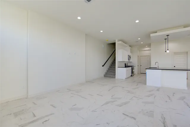an empty room with wooden floor and staircase
