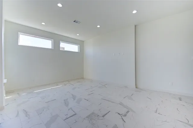 a large white kitchen with cabinets and wooden floor