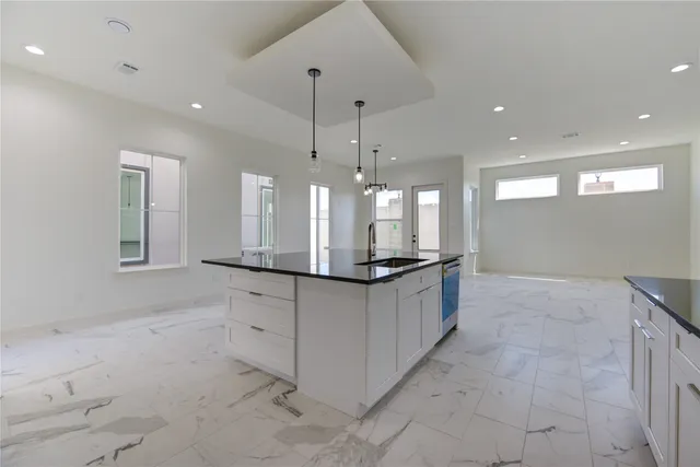 a large kitchen with kitchen island a sink a counter space and a chandelier