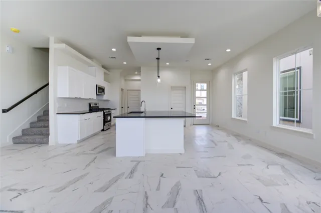 a kitchen with granite countertop a sink and cabinets