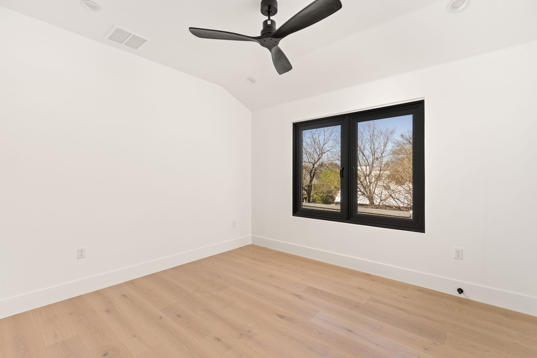1610 Harvey Street, Unit 2 Austin, TX 78702 - Photo 23 of 38 Empty room with lofted ceiling, light wood-style flooring, and a ceiling fan