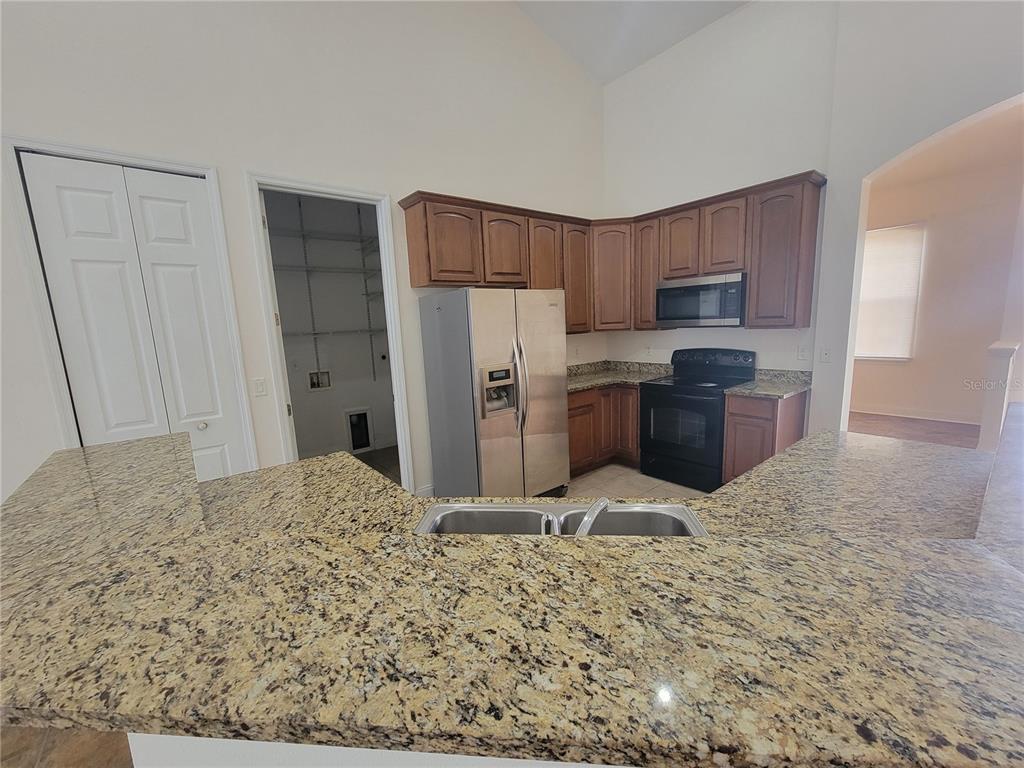 13092 Southwest 84th Terrace Road Ocala, FL 34473 - Photo 3 of 12 a large kitchen with a refrigerator and a sink