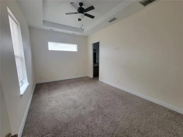 en empty room with windows and fan