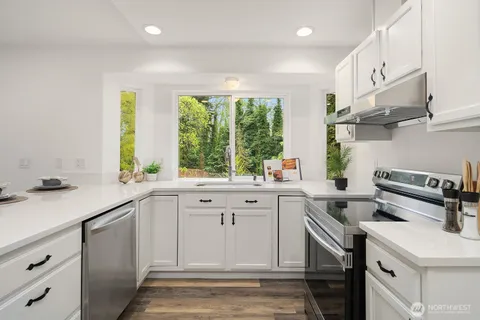 a kitchen with a sink stove top oven and cabinets