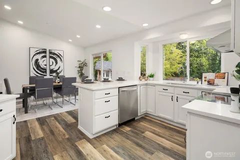 a kitchen with a sink appliances cabinets and a large window