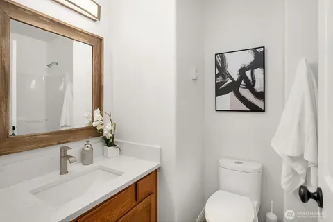 a bathroom with a toilet sink vanity and mirror