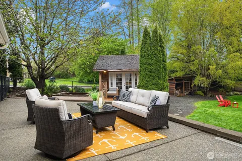 a view of a house and couches with wooden floor and fence