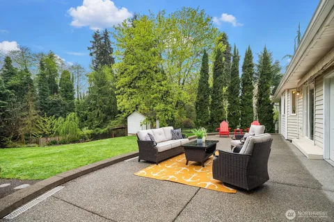 a view of a patio with couches and a table and chairs with wooden fence
