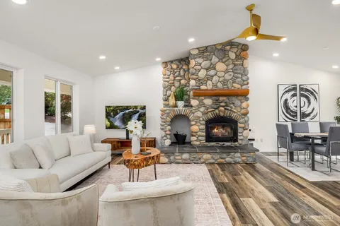 a living room with furniture a fireplace and a chandelier