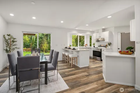 a kitchen with kitchen island wooden cabinets and dining table