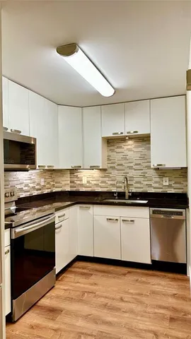 a kitchen with stainless steel appliances granite countertop a stove a microwave and oven