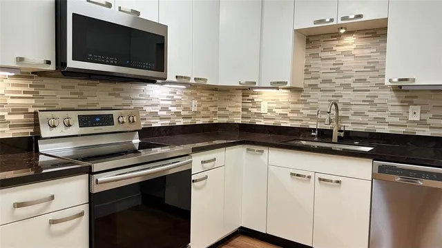 a kitchen with granite countertop a refrigerator and a sink