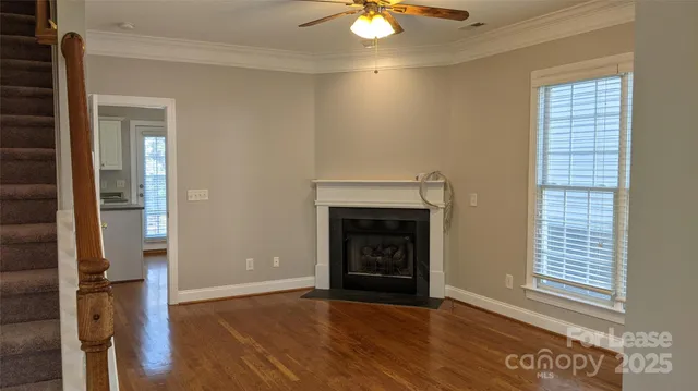 an empty room with wooden floor a fireplace and windows