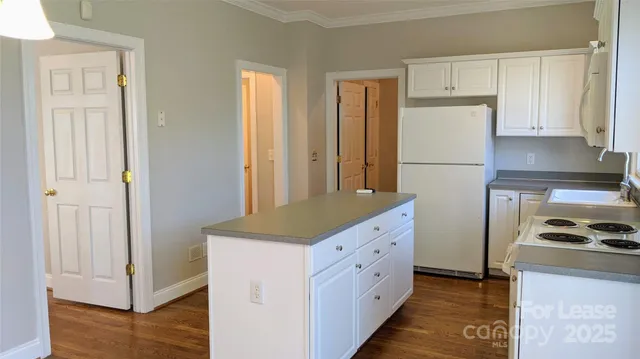 a kitchen with white cabinets and refrigerator