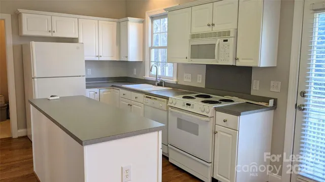 a kitchen with granite countertop a sink stove and refrigerator