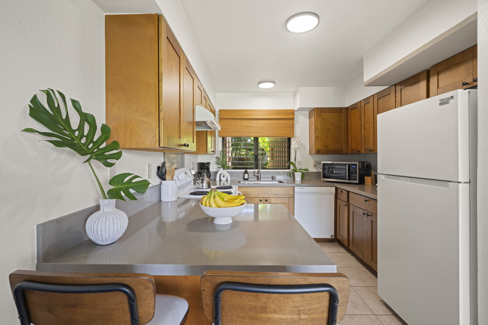 410 Papaloa Road, Unit 316 Kapaa, HI 96746 - Photo 9 of 30 a kitchen with a refrigerator and a sink