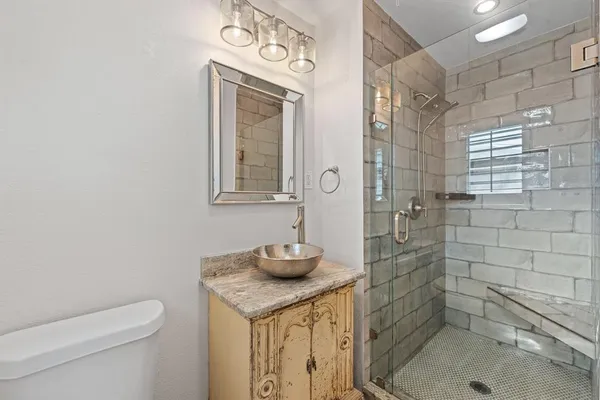 a bathroom with a granite countertop sink toilet and shower
