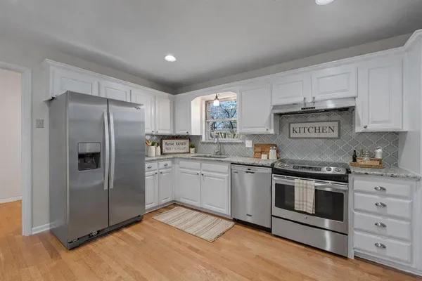 a kitchen with stainless steel appliances granite countertop a stove a refrigerator and a refrigerator