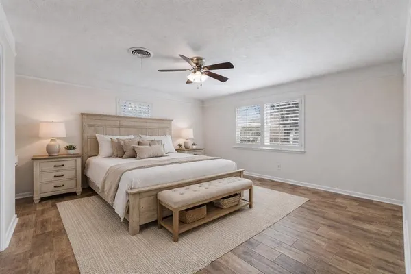a spacious bedroom with a bed and a chandelier