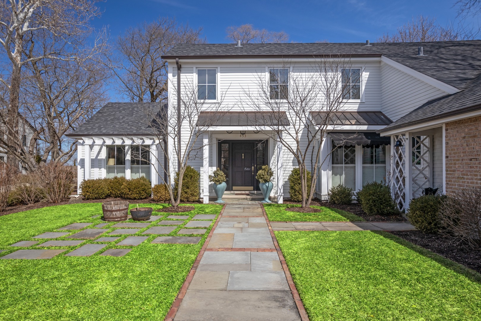 453 Sheridan Road Winnetka, IL 60093 - Photo 1 of 15 a front view of a house with garden and porch