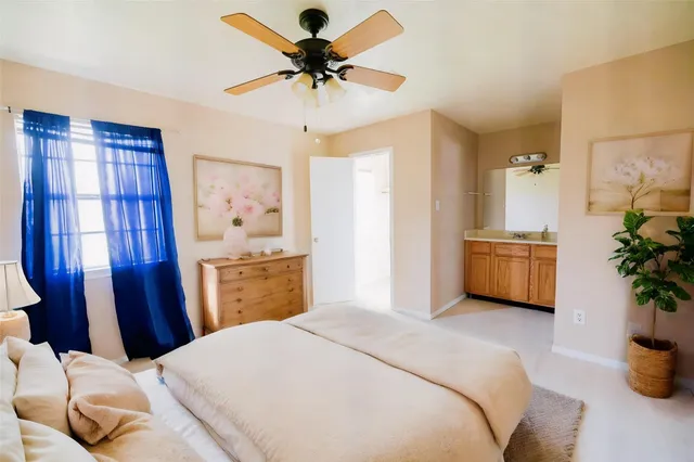 a bedroom with a bed dresser flowerpot and window