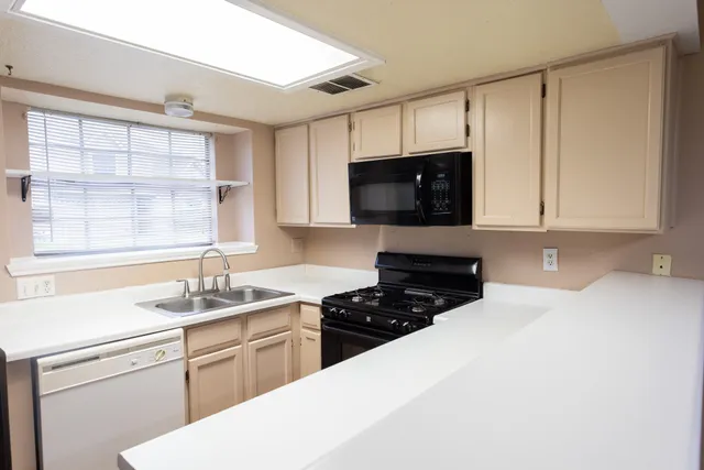 a kitchen with stainless steel appliances a sink a stove a microwave and cabinets