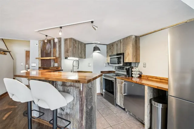 a kitchen with granite countertop a table chairs microwave and cabinets