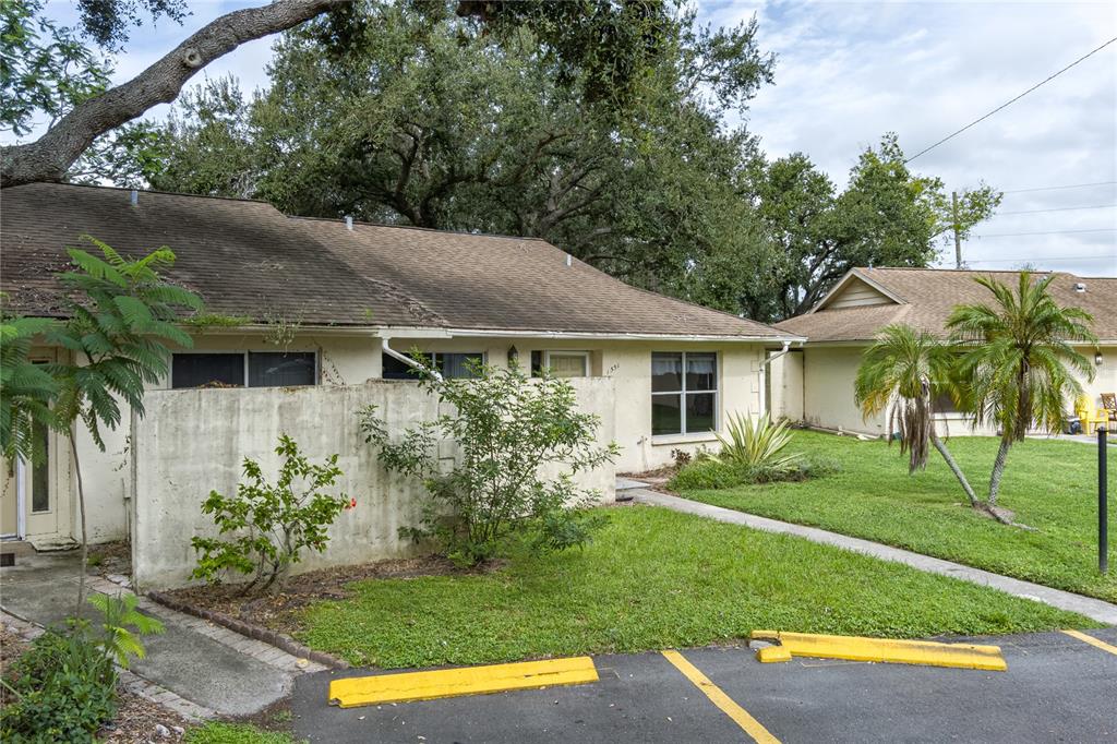 a view of house with a yard and potted plants