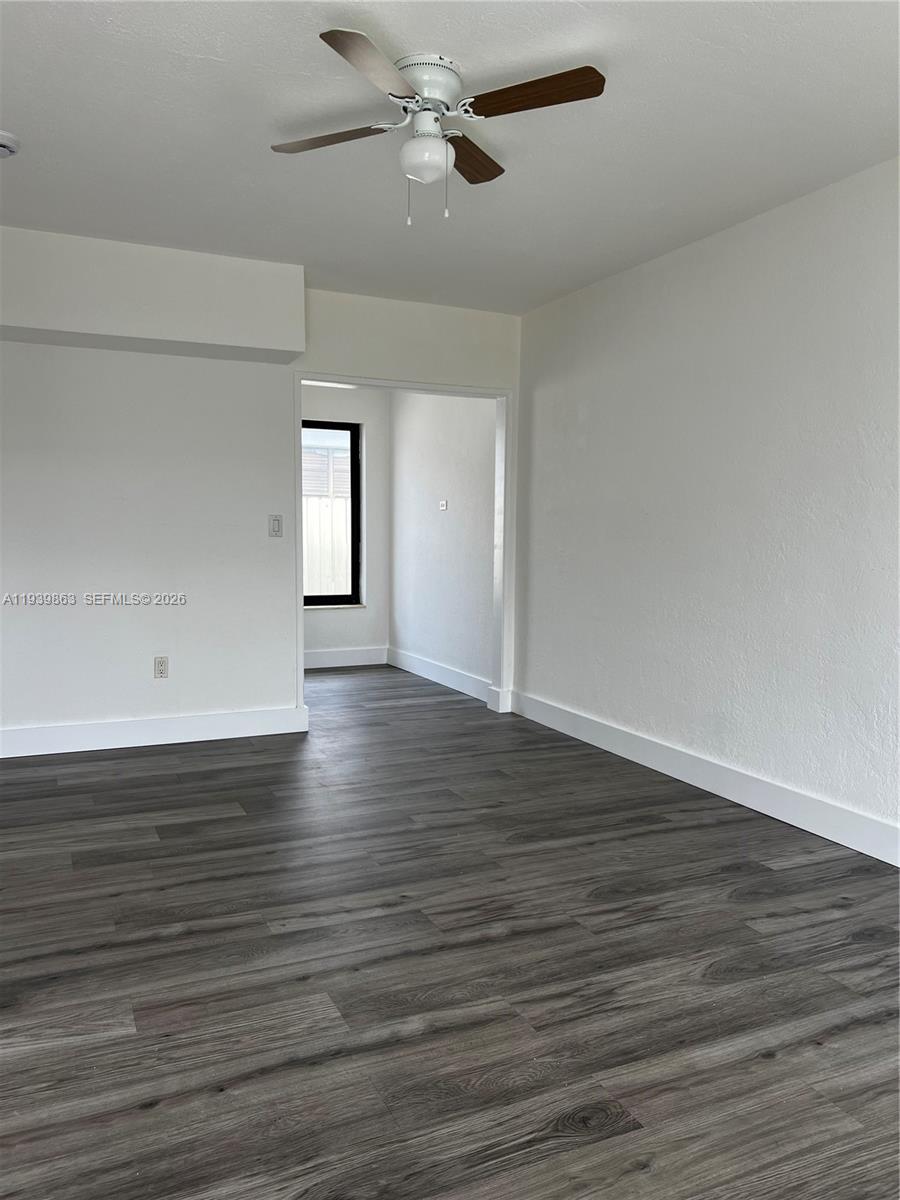 650 83rd Street, Unit 1 Miami Beach, FL 33141 - Photo 20 of 37 an empty room with wooden floor chandelier fan and windows