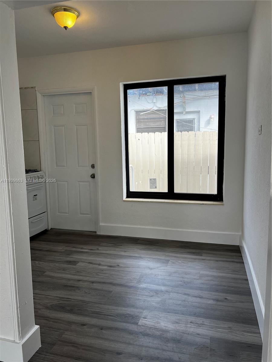 650 83rd Street, Unit 1 Miami Beach, FL 33141 - Photo 23 of 37 a view of an empty room with wooden floor and a window