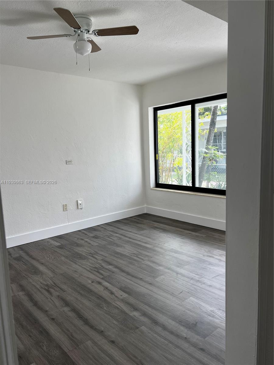 650 83rd Street, Unit 1 Miami Beach, FL 33141 - Photo 28 of 37 an empty room with wooden floor and windows
