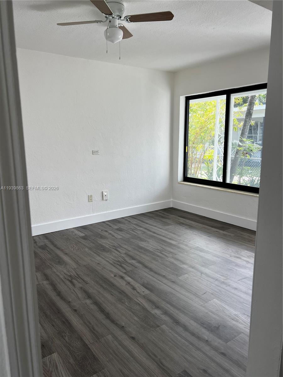 650 83rd Street, Unit 1 Miami Beach, FL 33141 - Photo 29 of 37 an empty room with wooden floor and windows